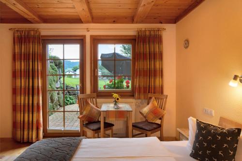 a bedroom with a bed and a table and a window at Hirschsprung in Breitnau