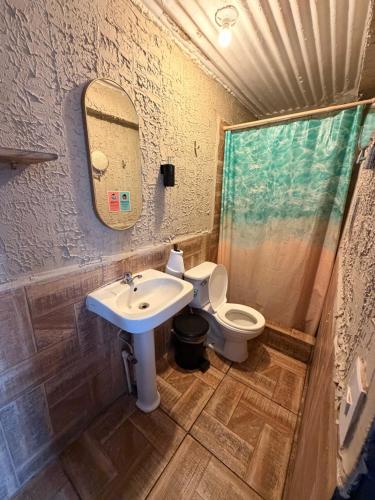 a bathroom with a sink and a toilet at Karma Muse Hotel in La Libertad