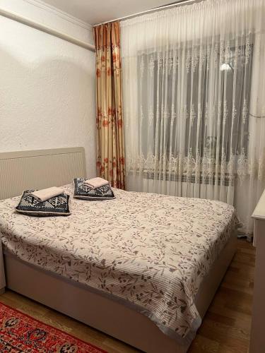 a bedroom with a bed with two pillows on it at Keremeti guest house in Dzhangyaryk
