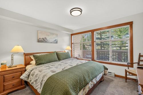 a bedroom with a bed and two windows at Powderhorn Suite in Solitude