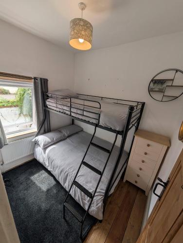 a bedroom with a bunk bed and a window at Quaint Cottage in Charming Evesham in Evesham