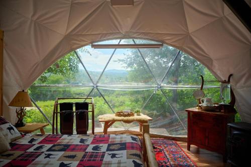 a bedroom with a large window in a tent at Johnson Dome in Johnson