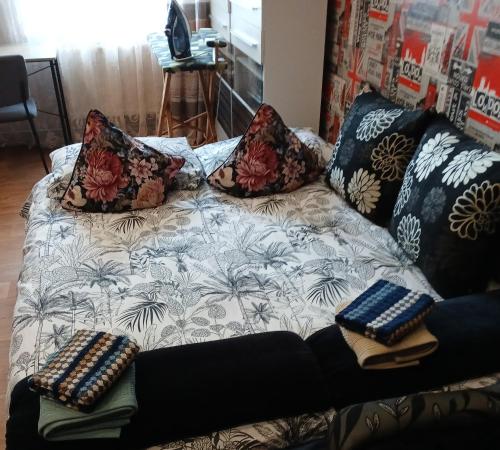 a couch with pillows on it in a living room at Tosmare Apartament in Liepāja