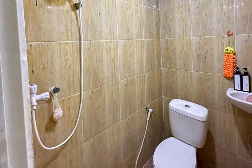 a bathroom with a shower and a toilet and a sink at RedDoorz at Jatisampurna 