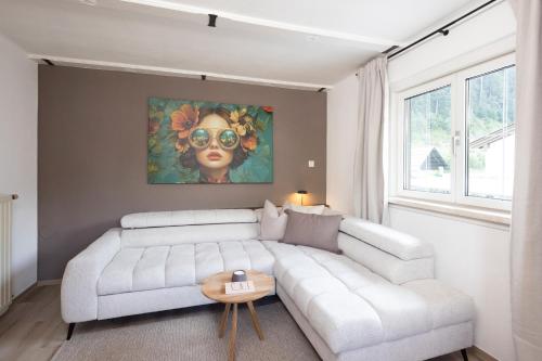 a living room with a white couch and a painting at Familienparadies - Chalet Hoamatl in Achenkirch