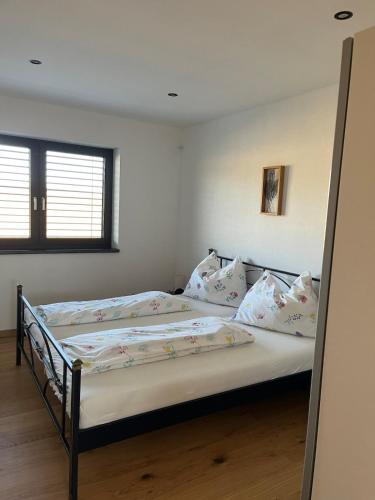 a bedroom with a bed with white sheets and pillows at Apartment Naturblick in Strem