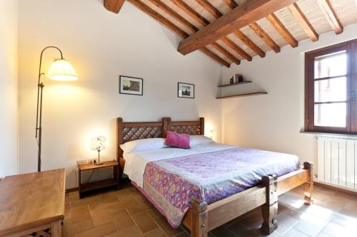 a bedroom with a bed and a table and a window at Casale Pundarika in Riparbella