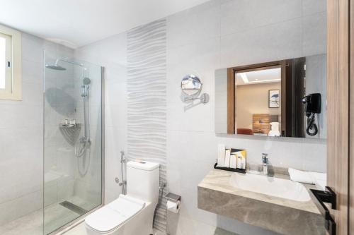 a bathroom with a toilet and a sink and a shower at Warwick Al Baha Hotel in Baljurashi