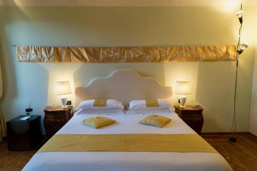 a bedroom with a large white bed with two pillows at La Villeggiatura in Venice