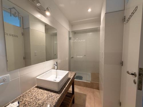 a white bathroom with a sink and a shower at Casa Calamar en Casa Pampa in Chapadmalal