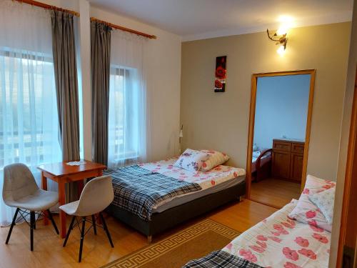 a bedroom with a bed and a desk and a mirror at Ostoja w Lipowcu in Jaśliska