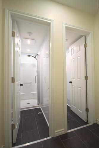 a bathroom with a walk in shower next to a door at La Victorienne in Louiseville