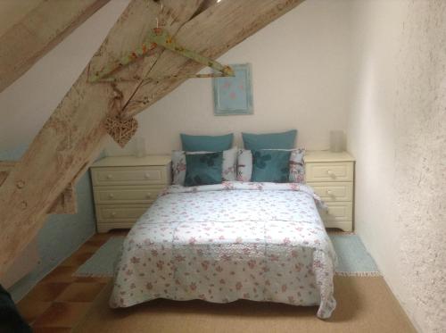 ein Schlafzimmer mit einem Bett und zwei Kommoden in der Unterkunft Le Bourg Remy Gites in Saint-Rémy-sur-Creuse