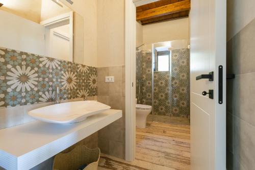 a bathroom with a sink and a toilet at Mulino 1220 in Scopello