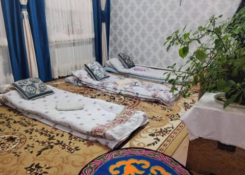 two beds sitting on the floor in a room at Keremeti guest house in Dzhangyaryk
