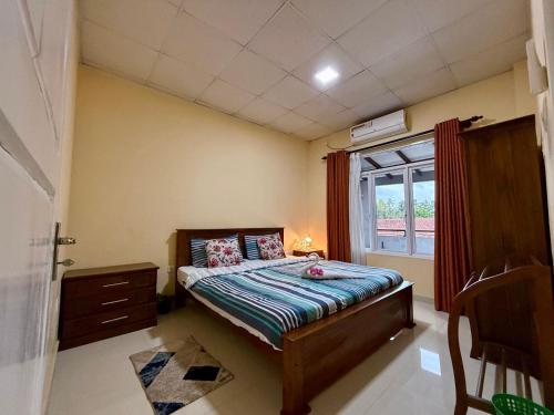 a small bedroom with a bed and a window at Judewin villa Negombo in Negombo