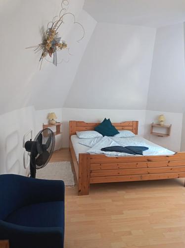a bedroom with a wooden bed and a chair at Elo Apartman in Csokonyavisonta