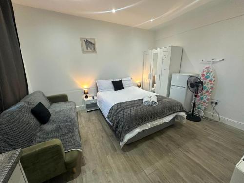 a bedroom with a bed and a couch in it at Wimbledon Family Studio Flat 1 in London