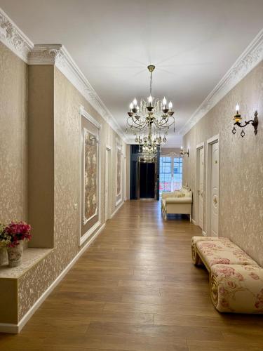 a hallway with a couch and a chandelier at Borjomi Classic Hotel in Borjomi