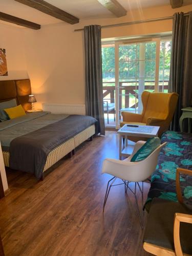 a hotel room with a bed and a living room at Willa Plejady in Karpacz