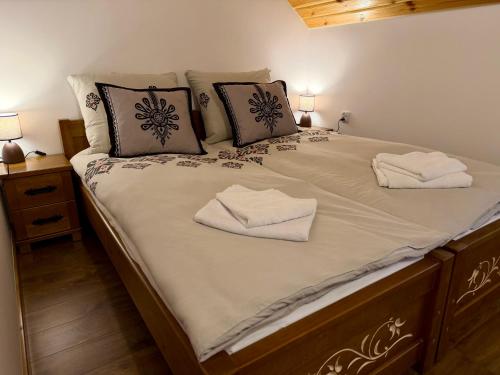 a large bed with two white towels on it at Gorczański Wierch in Maniowy
