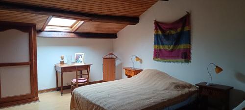 a bedroom with a bed and a desk and a window at Domaine de Béchegut in Marval