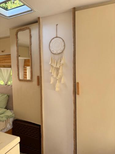 a room with a clock on the wall and a mirror at Przyczepa Kempingowa Beige in Jastarnia