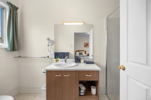 a bathroom with a sink and a shower at Maynestay Motel in Gunnedah