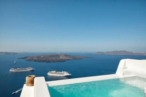 a swimming pool with boats in the water at Villa Murat in Fira