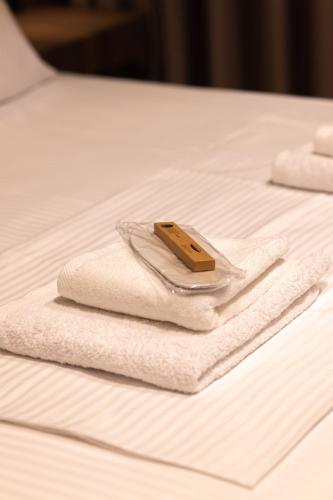 a pile of towels sitting on a bed at Aurum Hotel in Palasë