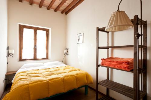 a bedroom with a yellow bed and a window at Casale Pundarika in Riparbella