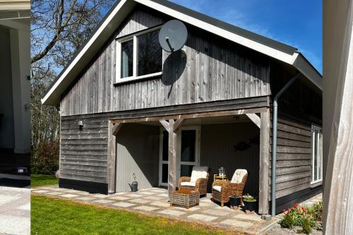 a barn with two chairs on a patio at Vakantiehuis Zeevogel - Julianadorp aan Zee in Julianadorp