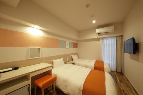a hotel room with two beds and a desk and a computer at SARASA HOTEL Shinsaibashi in Osaka