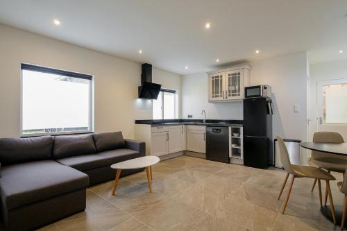 a living room with a couch and a table and a kitchen at Beachstudio - Centrum Callantsoog aan Zee in Callantsoog