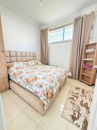 a bedroom with a bed with a floral comforter at Sea et sun appartement in Tangier