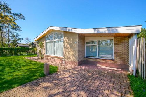 a brick house with a brick driveway at Vakantiehuis Duynloper - Julianadorp aan Zee in Julianadorp