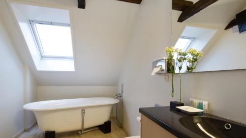 a bathroom with a tub, toilet and sink at Best Western Hotel Herman Bang in Frederikshavn