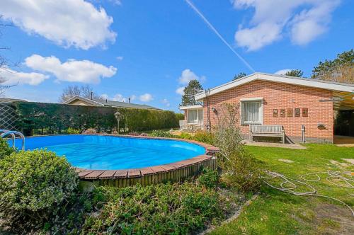 a swimming pool in the yard of a house at Vakantiehuis Springtij met privé zwembad - Julianadorp aan Zee in Julianadorp