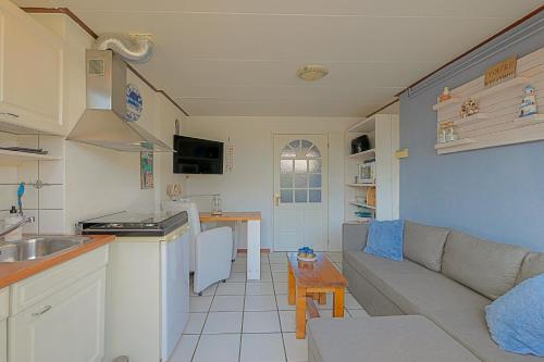 a kitchen and a living room with a couch and a table at Tiny House Petite - Callantsoog aan Zee in Callantsoog