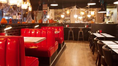 a restaurant with red chairs and tables in a room at Best Western Hotel Herman Bang in Frederikshavn