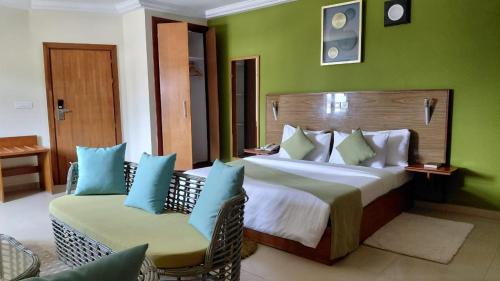 a bedroom with a large bed and two chairs at Le Ranch Hôtel San-Pedro in San-Pédro