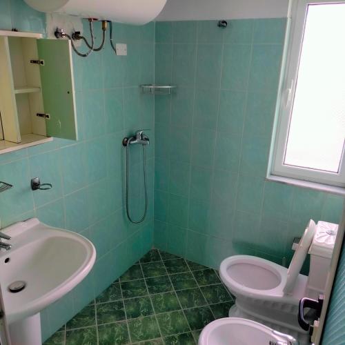 a bathroom with a sink and a toilet and a shower at Beach Guest House in Durrës