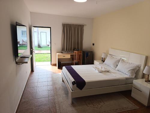 a bedroom with a bed and a desk in it at Casa Erica in Soyo