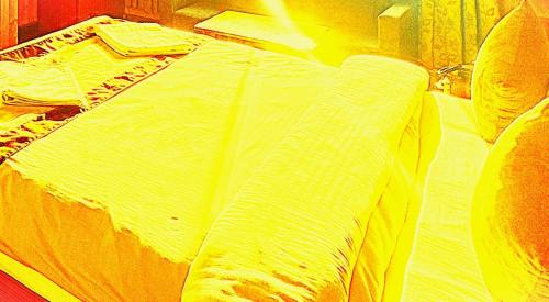 a close up of a bed in a room at The Trisha Hotel in kolkata