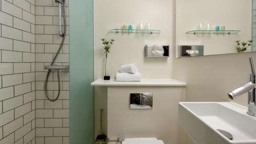 a bathroom with a toilet and a sink and a shower at Best Western Hotel Herman Bang in Frederikshavn