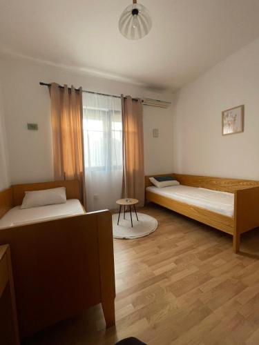 a room with two beds and a table in it at Vinarija Andjusic in Dračevo