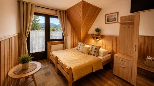 a bedroom with a bed and a window at Willa POŚREDNIA - widok na Tatry z każdego pokoju in Zakopane