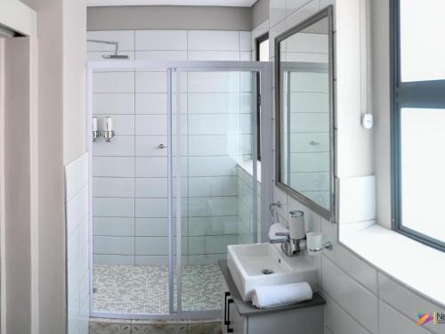 a bathroom with a sink and a shower at Next To Apartment Hotel in Pretoria