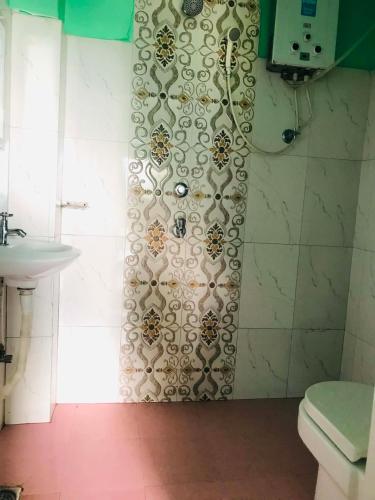 a bathroom with a shower with a toilet and a sink at Gauri Shanker Hotel and Lodge in Dharān Bāzār