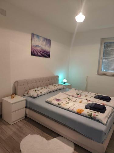 a bedroom with a large bed with a white bed frame at Sokak Apartman in Bihać